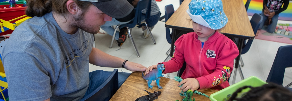 Student teaches child about dinosaurs